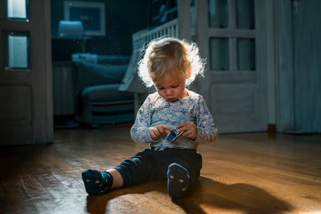 girl in white and blue long sleeve shirt sitting on floor